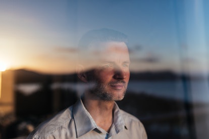 Man looking out large glass window and smiling