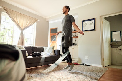 Man jumping rope in his living room during a home workout session.