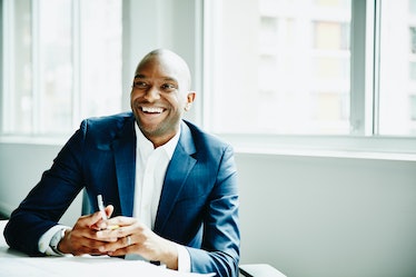 Man in business suit smiling while sitting in a conference room