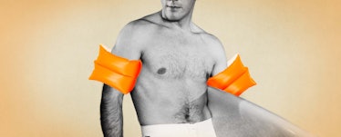 Man wearing orange arm floaties while holding a surf board. 