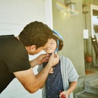 A dad straps a helmet onto his child's head.